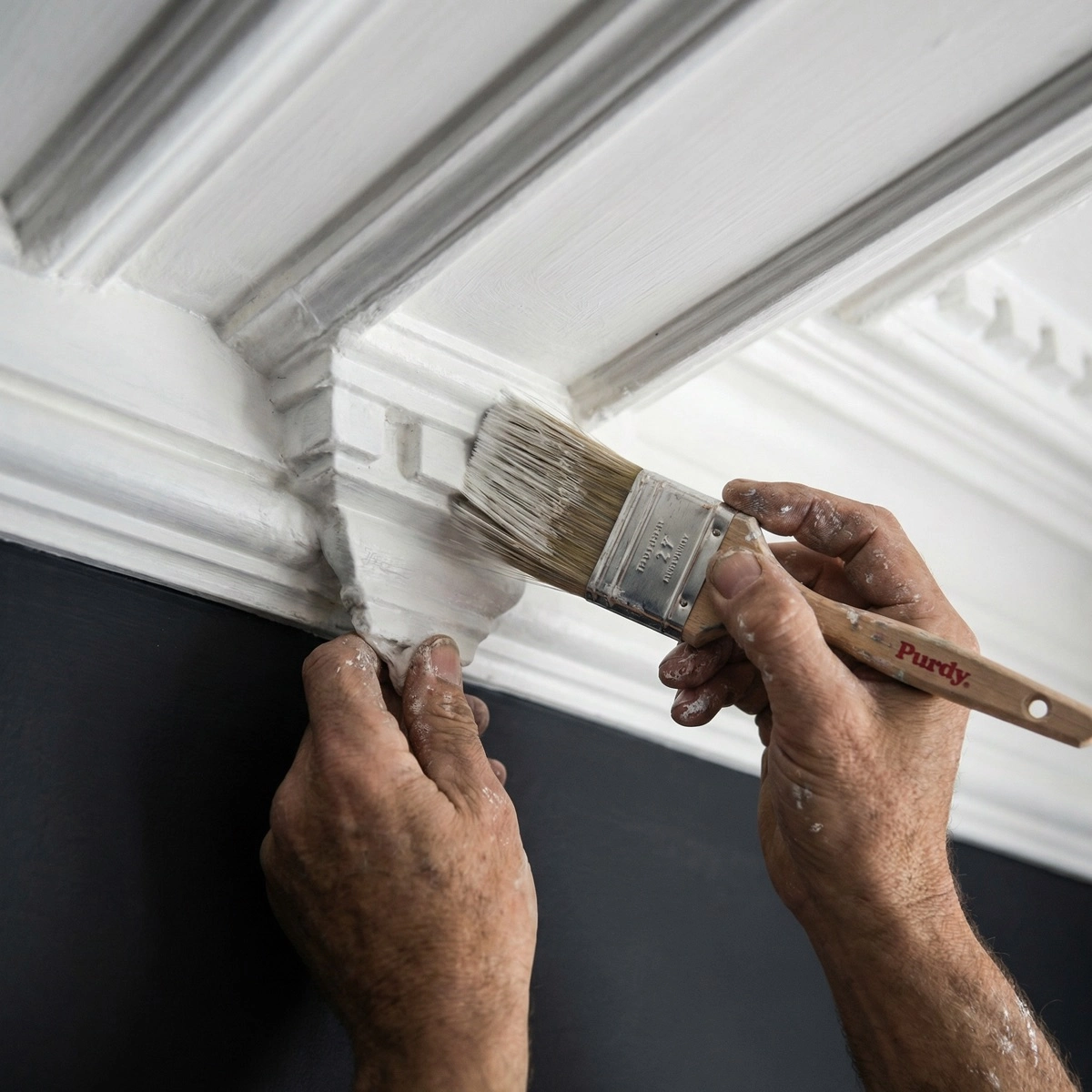 Expert painter hand-cutting intricate Victorian plaster crown molding with Purdy brush — Washington
